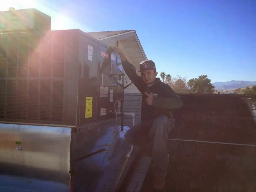 HVAC technician performing Boiler Repair on a rooftop unit in Madera